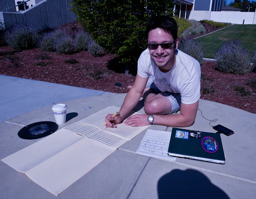 estudiante sentado en el suelo trabajando en una partitura musical
