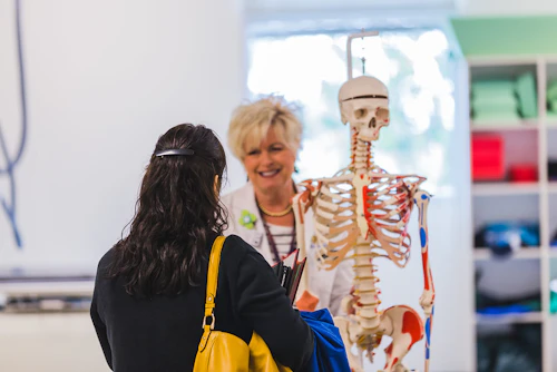 Estudiante mirando un modelo de esqueleto