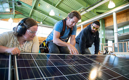 faculty with students learning solar installation