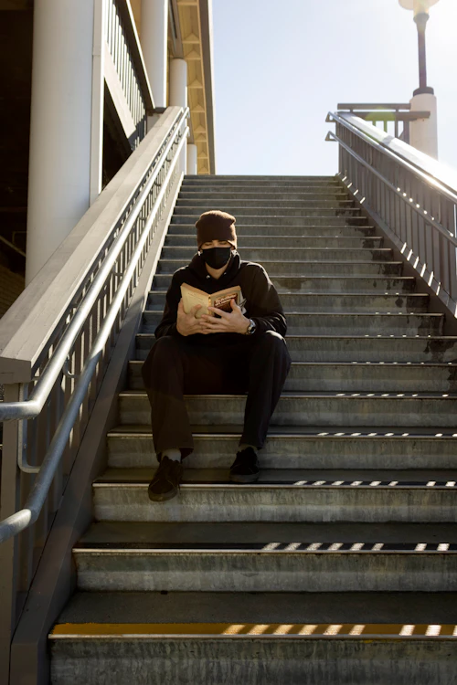 estudiante leyendo en los escalones