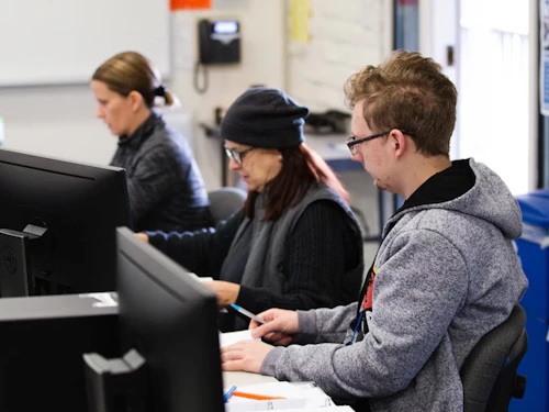 estudiantes trabajando en computadoras