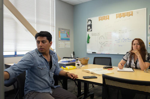 un tutor de estadísticas trabaja con un estudiante en la pizarra blanca