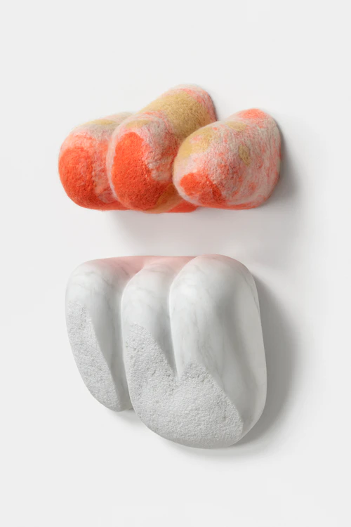 Stephanie Robison "Refection" naranja, amarillo y blanco en forma de nube tejida flotando sobre una nube de mármol en forma de pared escultura
