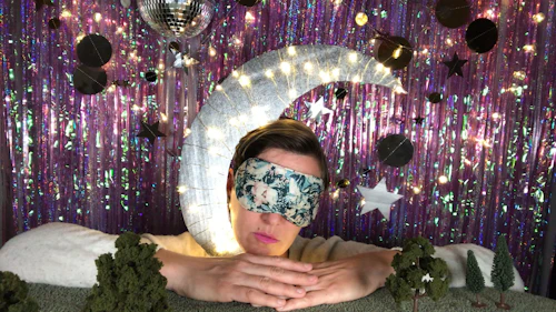 McCarthy "Fotografía diaria" de una persona usando una máscara para dormir sosteniendo un osito de peluche luna