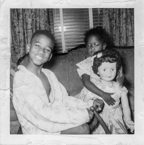 "White Doll" photography of two African American kids playing with a light skinned doll