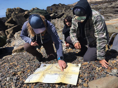 estudiantes examinando un mapa en el campo