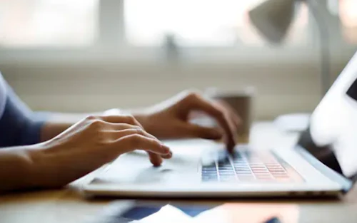 Manos tecleando en el ordenador portátil