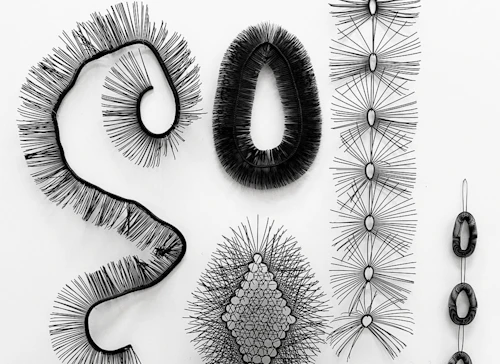 Cheryl Coon, detalle de la instalación "Símbiosis", esculturas negras hechas con tiras de cable zip