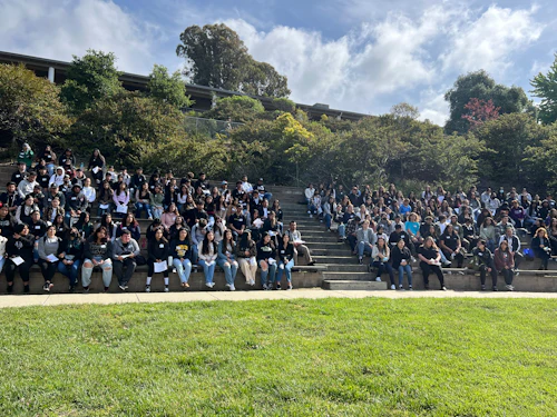 gran grupo de estudiantes sentados en un anfiteatro al aire libre
