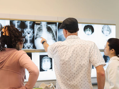 instructor de tecnología radiológica con estudiantes mirando radiografías