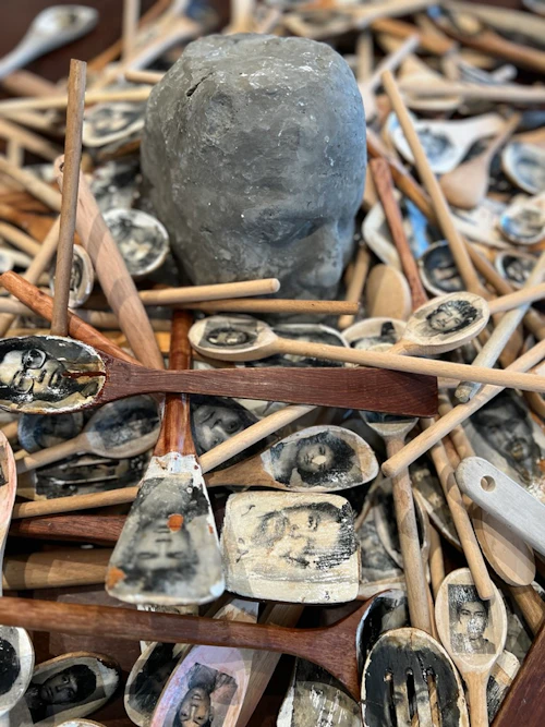 Victor Cartagena, detalle de instalación de cucharadas de madera con transferencias fotográficas de rostros