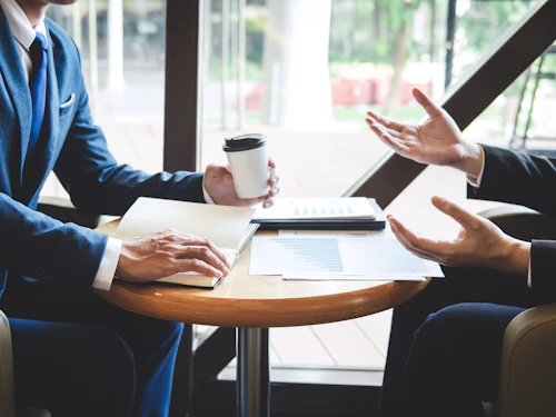 2 people with coffee and notes