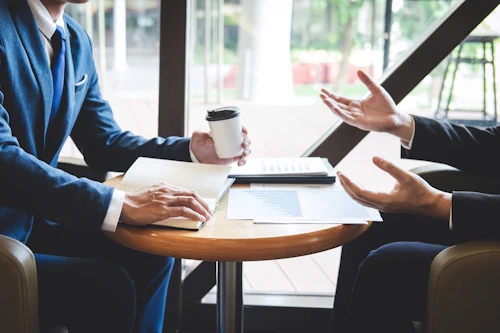 2 people with coffee and notes