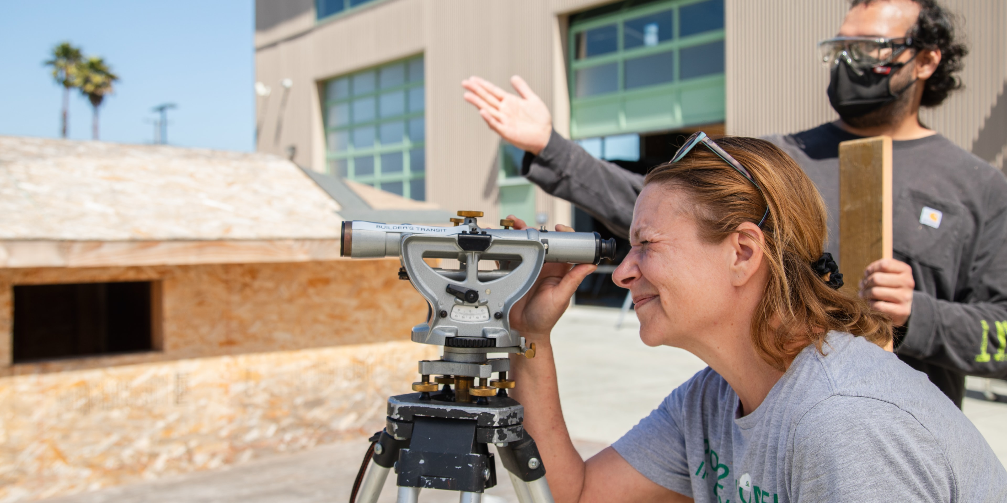 Mujer mirando a través del tránsito de construcción mientras un hombre gesticula en el fondo.
