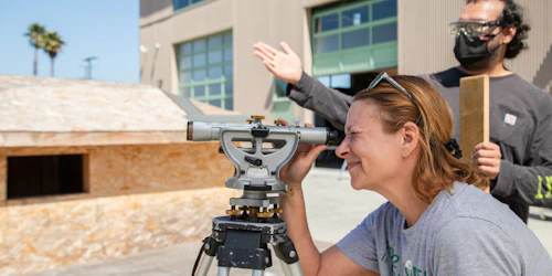 Mujer mirando a través del tránsito de construcción mientras un hombre gesticula en el fondo.