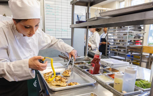 Chef femenina probando la temperatura de una pechuga de pollo