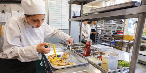 Chef femenina probando la temperatura de una pechuga de pollo
