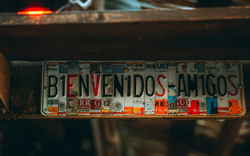 Piezas de placas de matrícula deletrean "Bienvenidos Amigos".