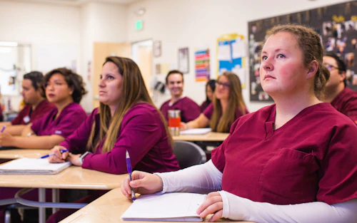 Un salón de clases con estudiantes en batas médicas