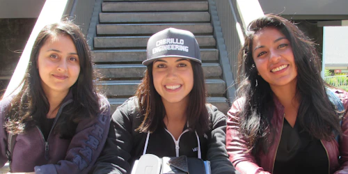 Three female engineering students smile at the camera