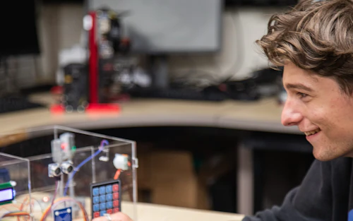 Un estudiante varón prepara un experimento en una mesa de laboratorio.
