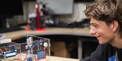 A male student sets up an experiment on a lab bench