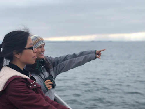 Students pointing at the ocean from a boat