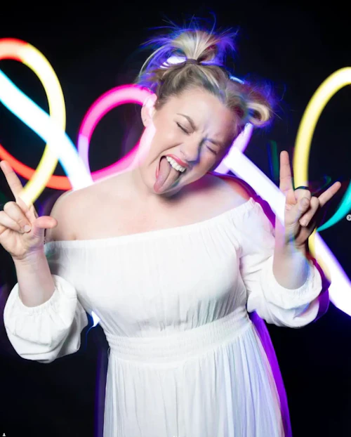 student with neon lights behind