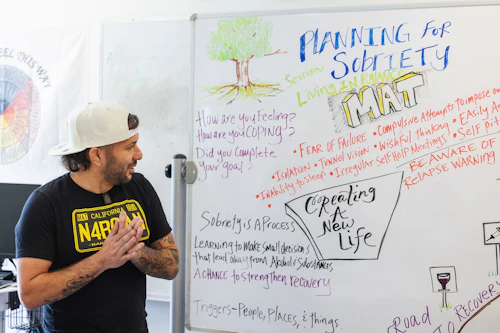 hombre hablando con un pizarrón blanco