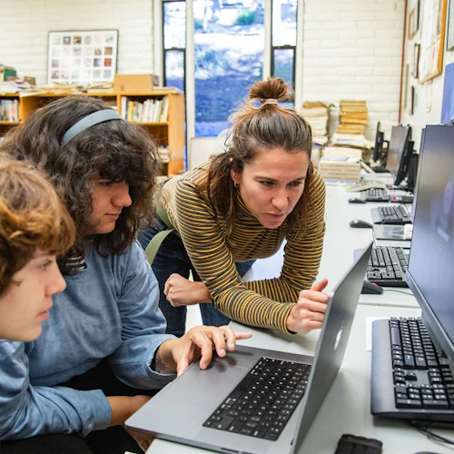 estudiantes con personal en computadoras portátiles