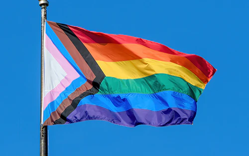 A pride flag blowing in the wind