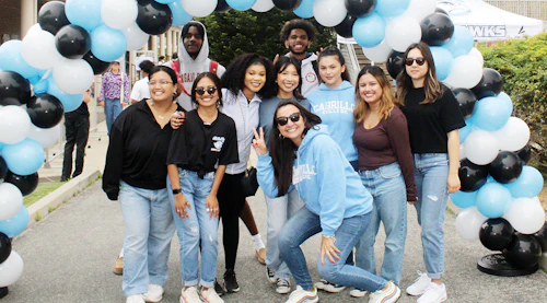 a group of students at Seahawks Take Flight event under a balloon arch