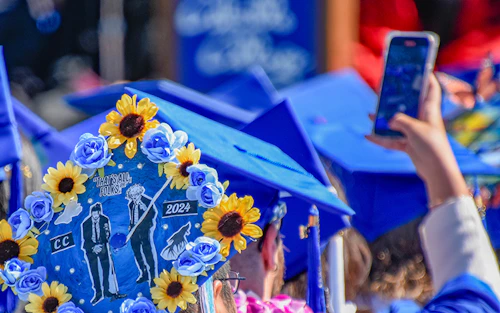 a Cabrillo graduate taking a photo with a cellphone