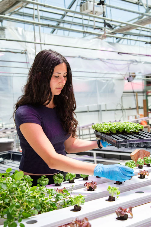 female student in the greenhouse