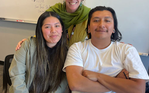 an engineering faculty smiles with two engineering students