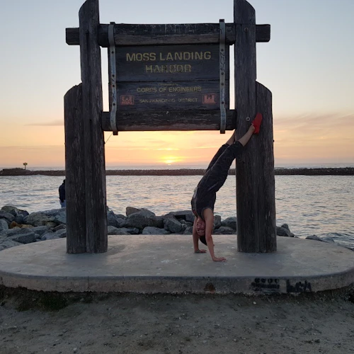 Skye doing a handstand at moss landing harbor