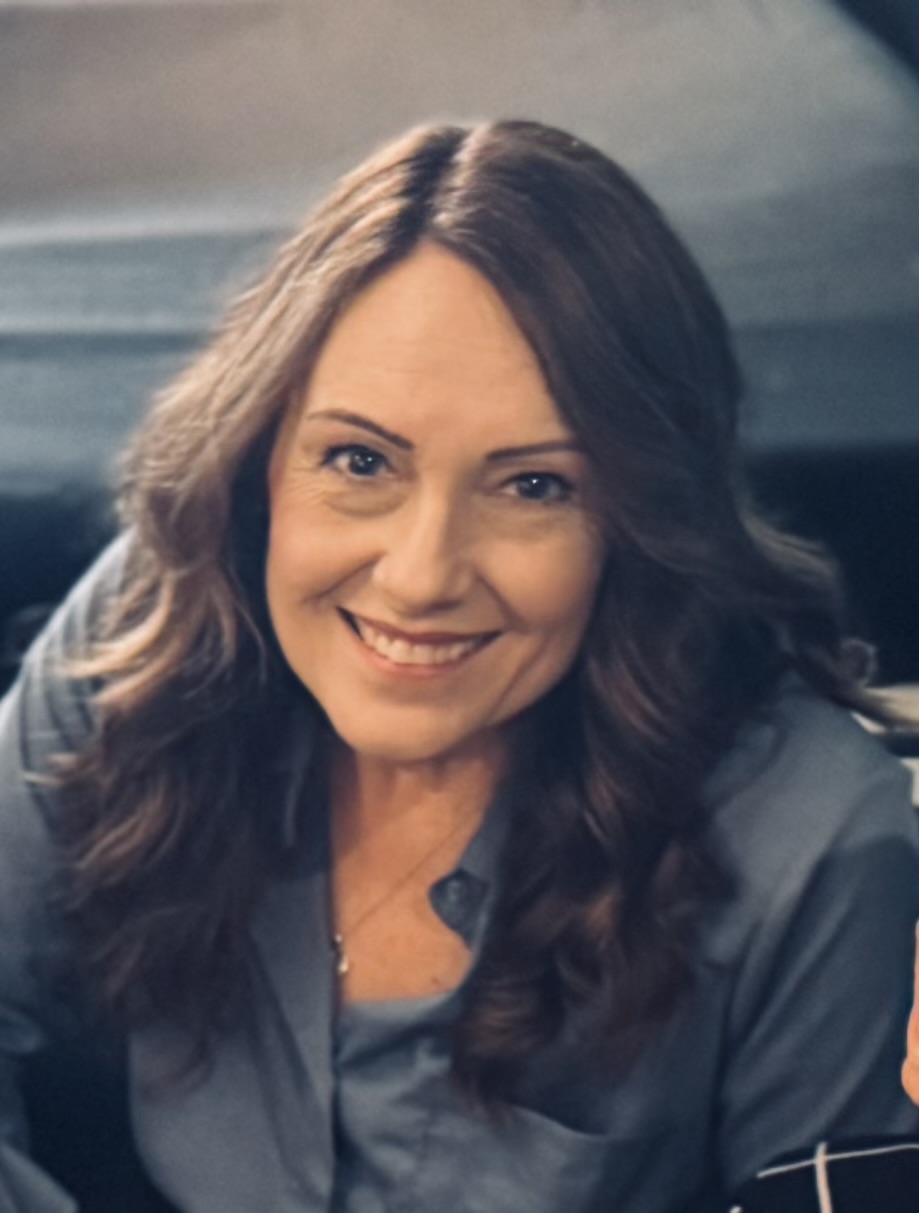 Picture of Ronnette with brown hair and wearing a blue shirt, brown hair