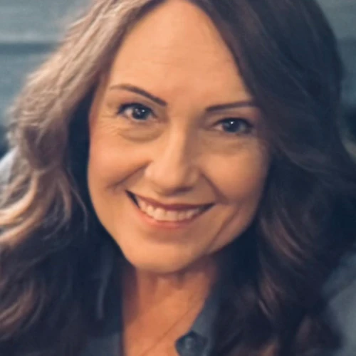 Picture of Ronnette with brown hair and wearing a blue shirt, brown hair