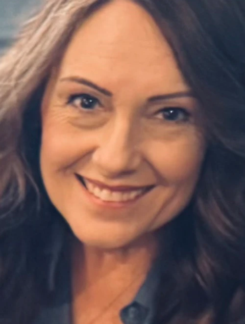 Picture of Ronnette with brown hair and wearing a blue shirt, brown hair