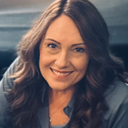 Picture of Ronnette with brown hair and wearing a blue shirt, brown hair