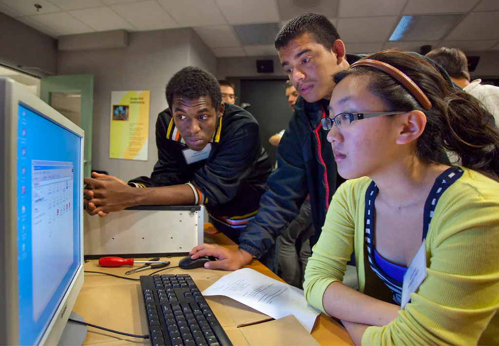 students working at a computer in class