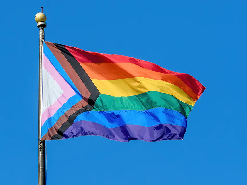 a pride flag blowing in the wind
