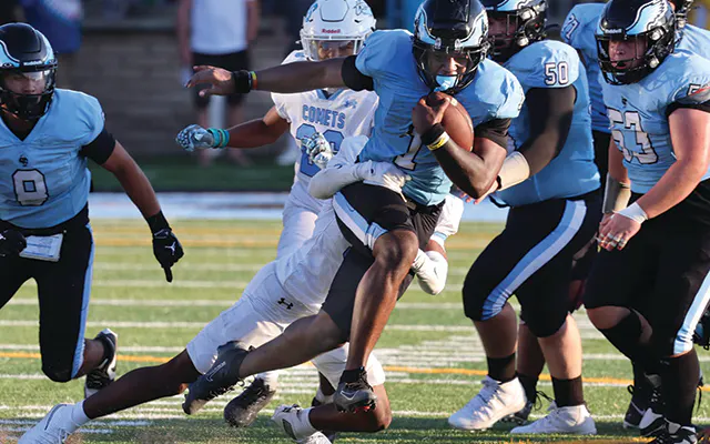 Cabrillo's football team runs with the ball during a game